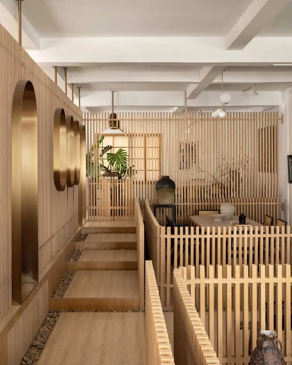 Vista d’insieme della teahouse artistica a Foshan con percorso in legno sopra ghiaia e ambienti separati da pareti in listelli verticali