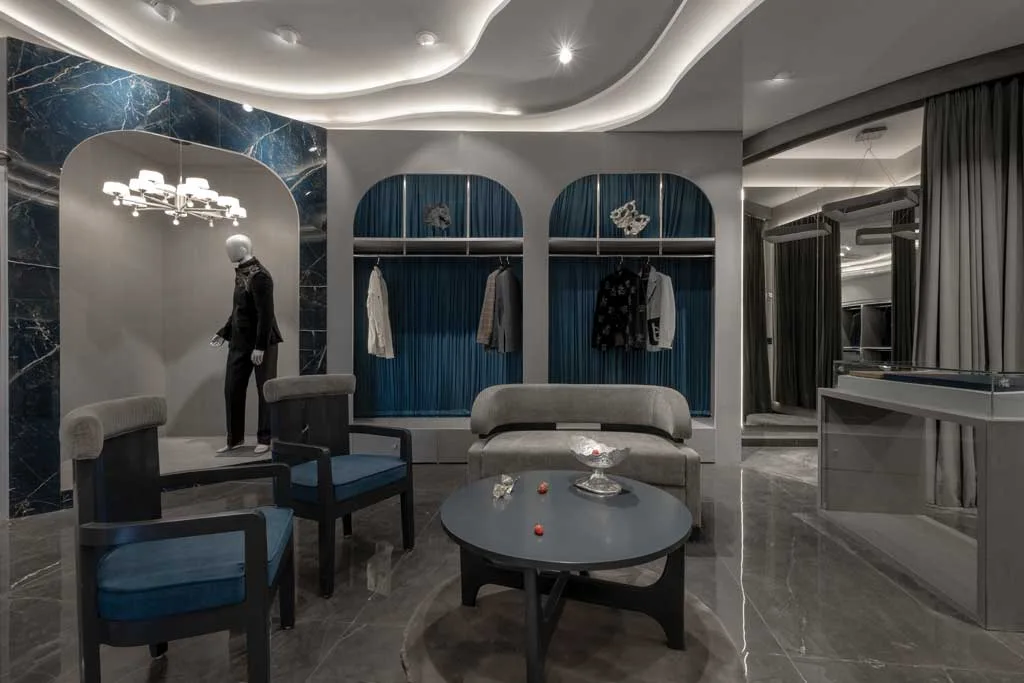 Display area of the Mukund Taneja Boutique in Amritsar with tailored mannequin, elegant furnishings, and scenographic lighting.