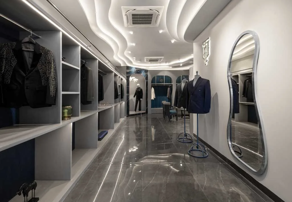 Corridor of the Mukund Taneja Boutique in Amritsar with custom furnishings, sculptural mirror, and illuminated wavy ceiling.