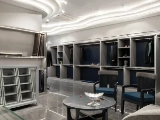 Interno della Boutique Mukund Taneja ad Amritsar con arredi su misura, sedute in velluto e soffitto scultoreo ondulato.