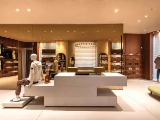 Interno della boutique Caposerio Uomo a Cefalù, progettata da Francesco Pitruzzella: arredi su misura, specchi bronzati e illuminazione Viabizzuno