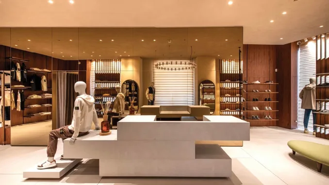 Interno della boutique Caposerio Uomo a Cefalù, progettata da Francesco Pitruzzella: arredi su misura, specchi bronzati e illuminazione Viabizzuno