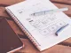 Quaderno con penne e smartphone, simbolo dell’evoluzione del design dal disegno manuale al digitale