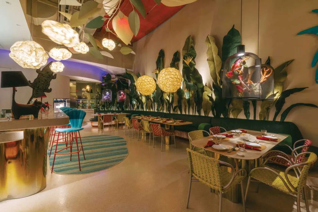 interni di FABLE Café + Lounge a Manila con arredi in rattan e luci floreali sospese