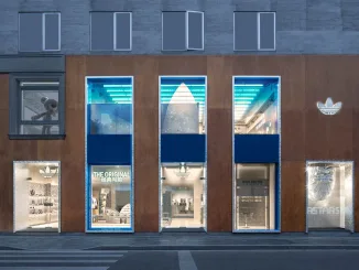 Facciata del flagship store Adidas Originals a Shanghai, progetto TOMO Design con tre finestre verticali e logo Trefoil illuminato