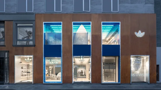 Facciata del flagship store Adidas Originals a Shanghai, progetto TOMO Design con tre finestre verticali e logo Trefoil illuminato