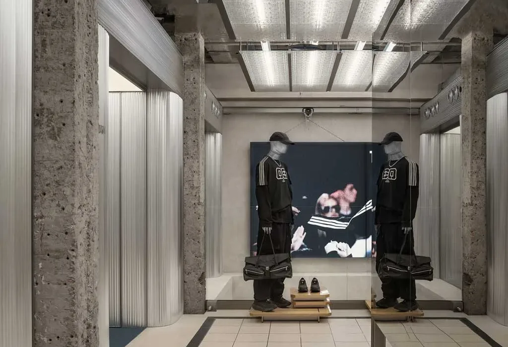 Camerini del flagship store Adidas Originals a Shanghai con superfici metalliche e manichini in total look nero