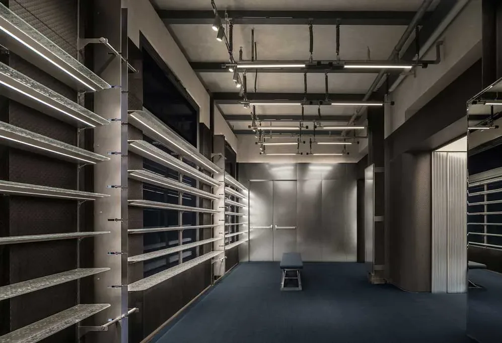 Area espositiva per sneaker del flagship store Adidas Originals a Shanghai con scaffalature in vetro e illuminazione tecnica