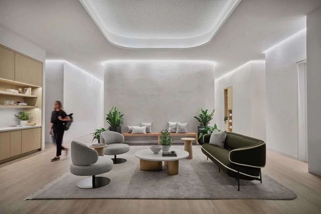 Lounge dal design minimalista con illuminazione a LED integrata, arredi moderni e palette neutra presso l'HSBC Zero Carbon HQ sostenibile
