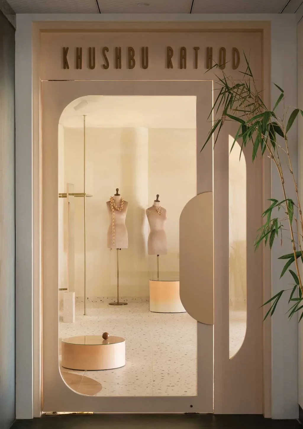 Ingresso boutique Khushbu Rathod a Hyderabad con logo dorato, manichini sartoriali e interior design firmato Beyond Spaces