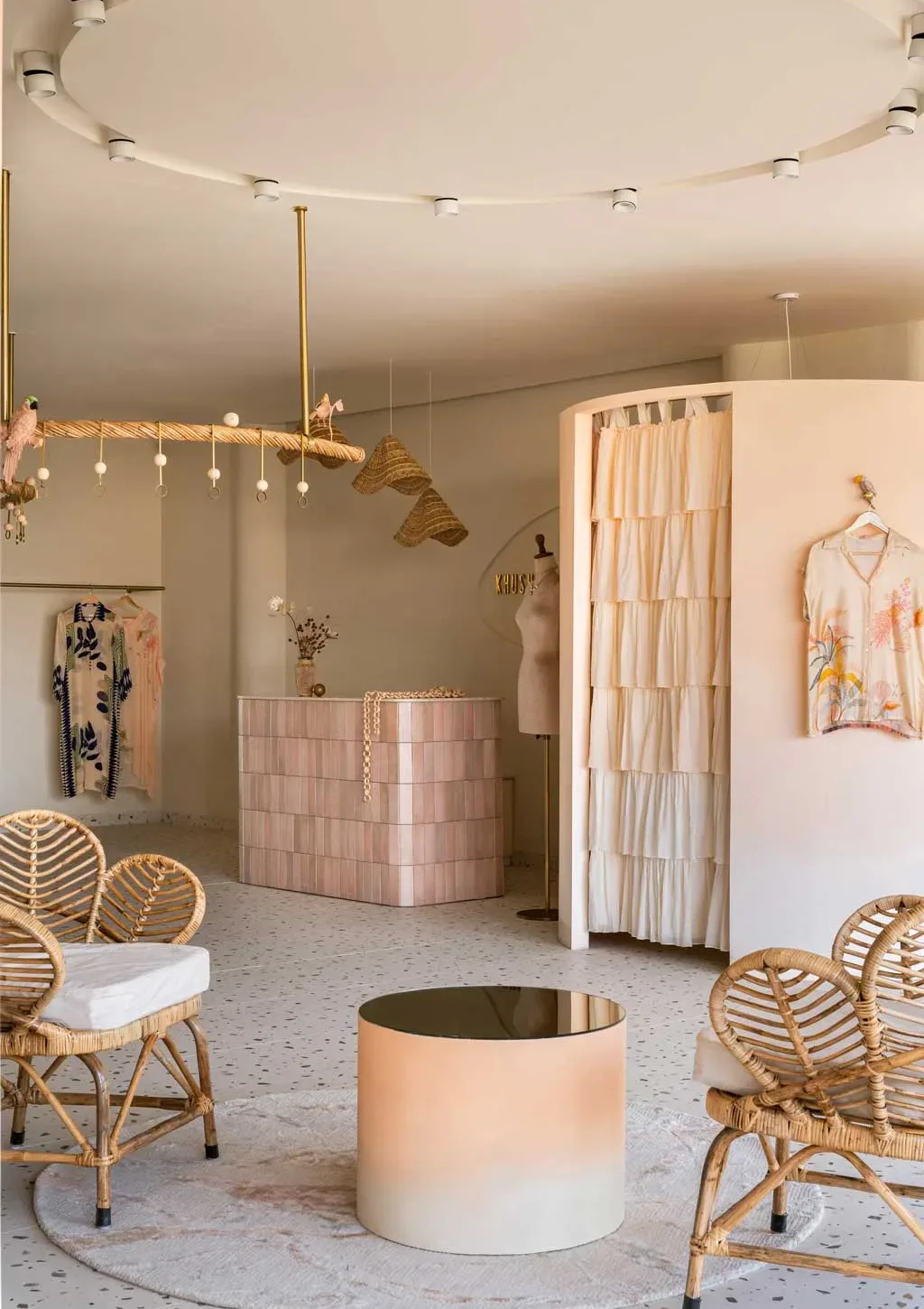 Vista interna della boutique Khushbu Rathod a Hyderabad con area reception, camerino curvo e arredi in rattan naturale