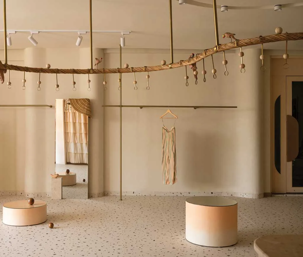 Interior of Khushbu Rathod boutique in Hyderabad with brass details, terrazzo flooring and organic design furniture by Beyond Spaces Design Studio
