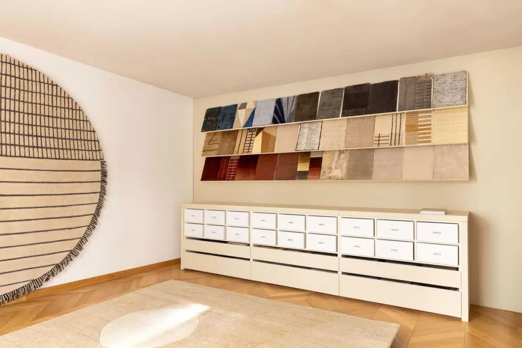 Spazio espositivo Amini a Saint-Germain-des-Prés con campionari di tappeti di design e allestimento minimalista