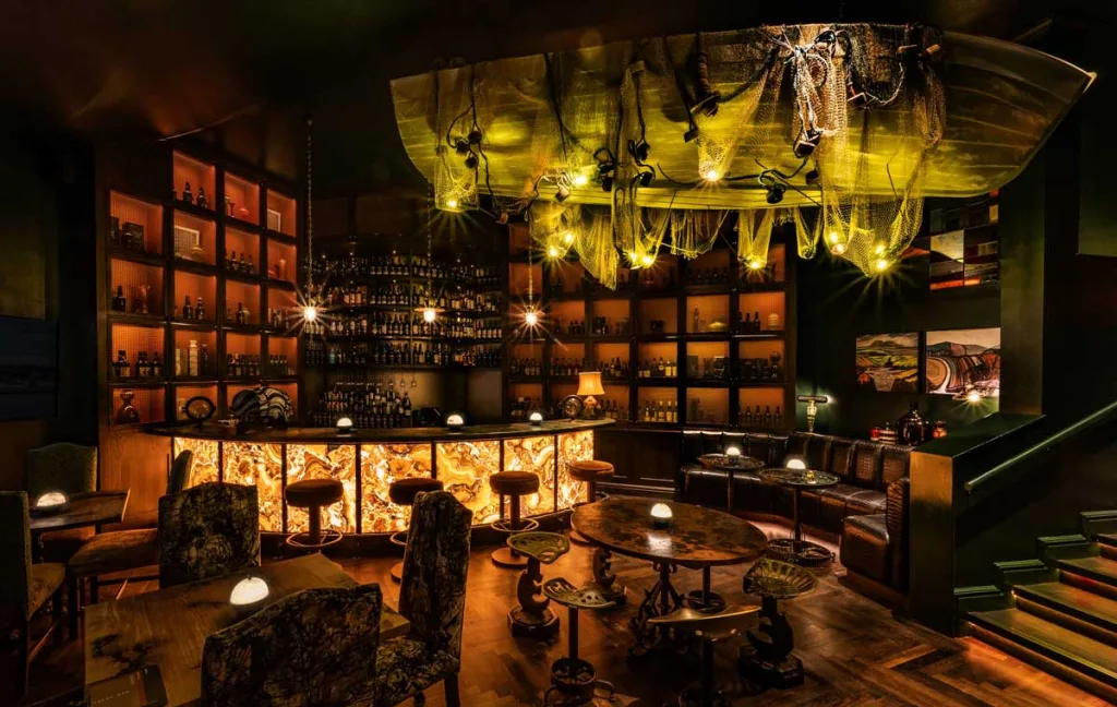 Interno dell’Islay Bar di Ardbeg House Islay con bancone retroilluminato