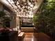 Ingresso di HIO Sushi Lab a Palermo, bar con bonsai, installazione di farfalle sospese e parete in bamboo progettati da Luigi Smecca Architetti.