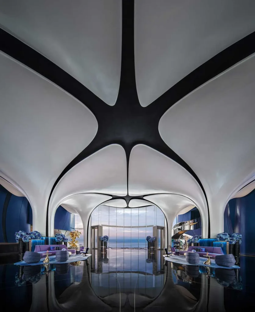 Lobby del MGM Shenzhen progettato da CCD, con soffitto curvilineo bianco e nero, arredi sinuosi e vista panoramica sull’oceano