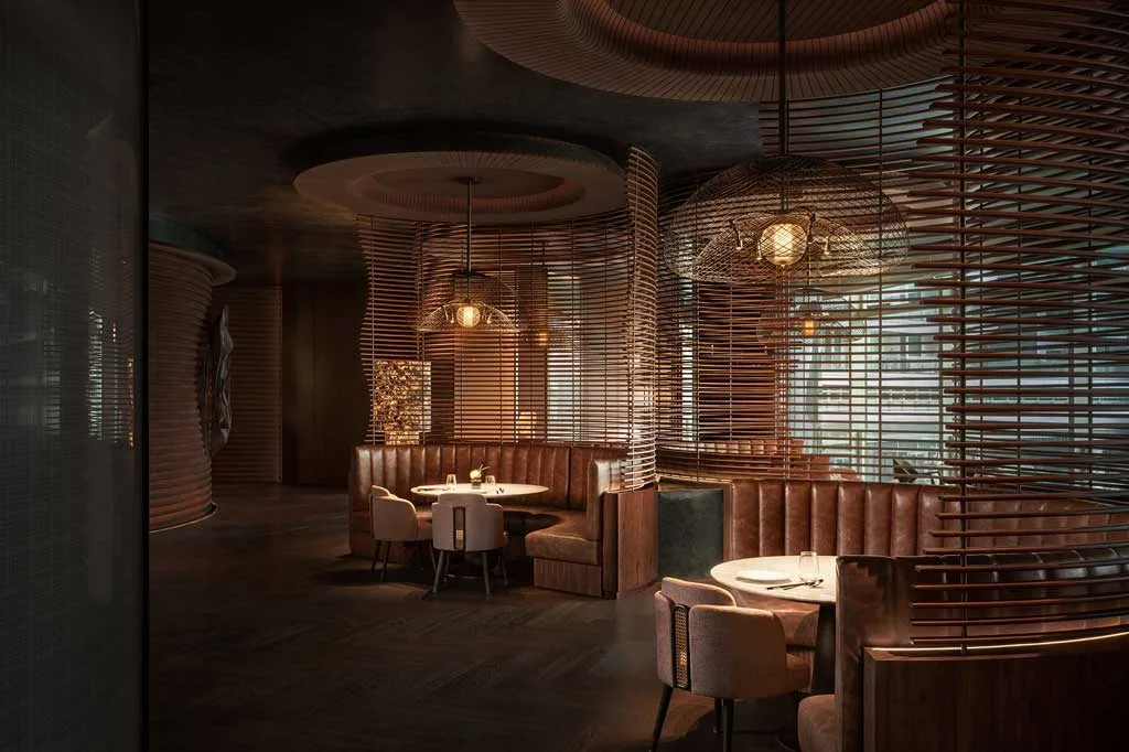 Ristorante del MGM Shenzhen progettato da CCD, con divisori in bambù intrecciato, arredi curvi in pelle e atmosfera calda e sofisticata.