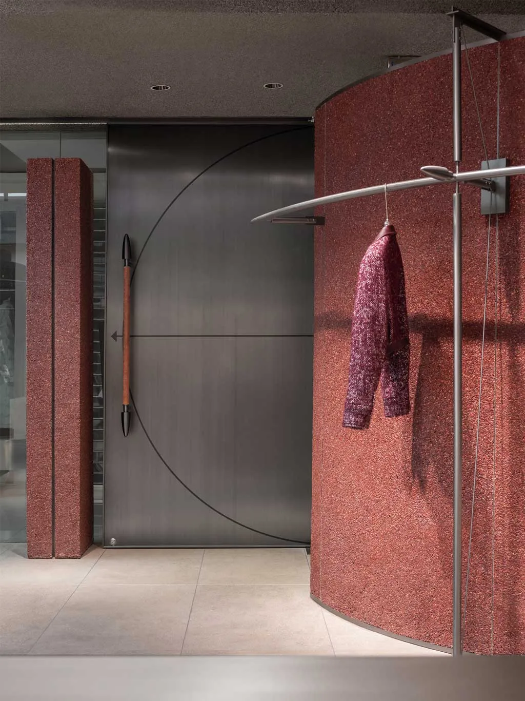 Area espositiva del RUI SPACETIME Concept Store con rivestimenti in travertino rosso e display in acciaio