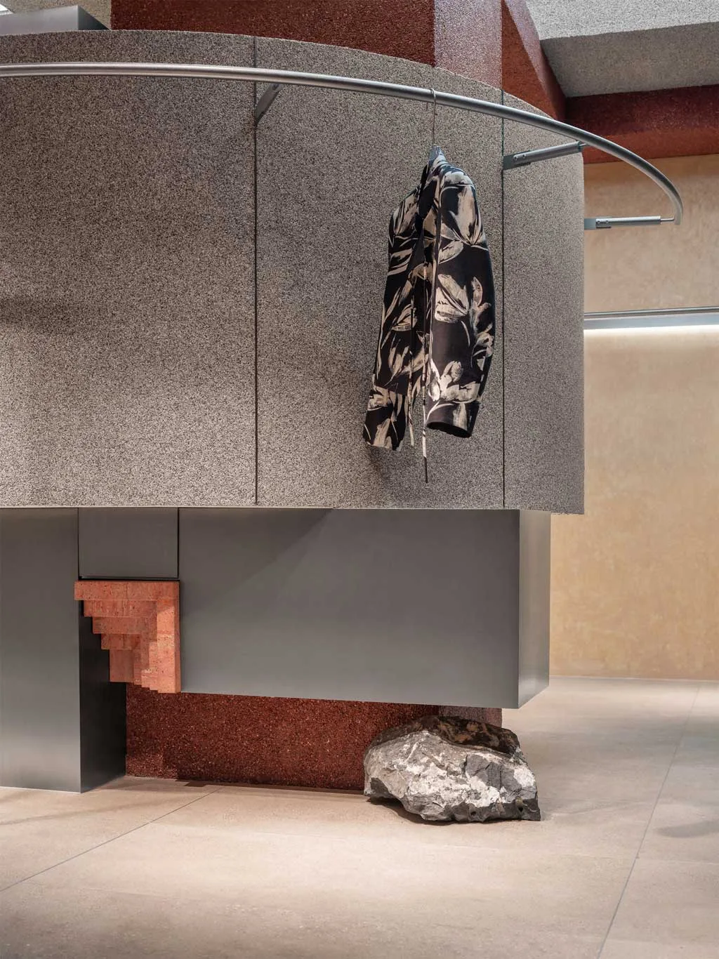 Vista interna con espositori metallici ad arco e rivestimenti rossi del concept store RUI SPACETIME