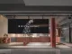 Vista esterna del RUI SPACETIME Concept Store a Shenzhen con facciata in vetro, rivestimenti in travertino rosso e installazione multimediale