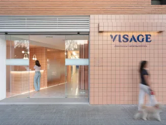 Visage Clinic arredamento cliniche dentali moderne firmato Vitale, ingresso con facciata rivestita in ceramica salmone e reception a vista.