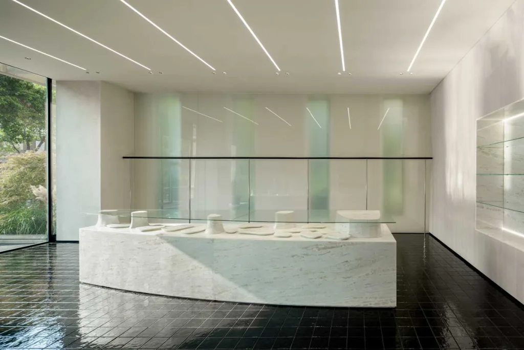 Isola centrale in marmo e vetro del concept store 7+ Select Shop – Glimmering Bay a Zhengzhou progettato da say architects