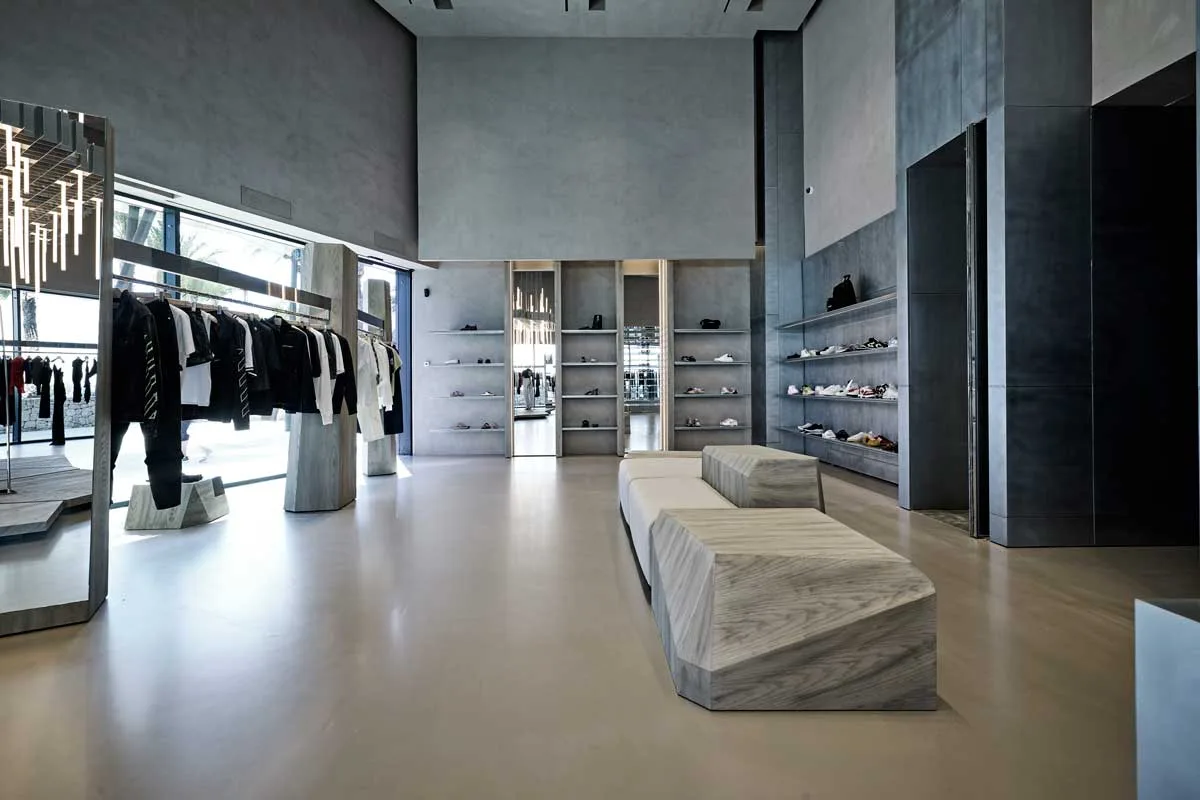Interno della boutique Antonioli Ibiza con arredi monolitici in legno e finiture metalliche
