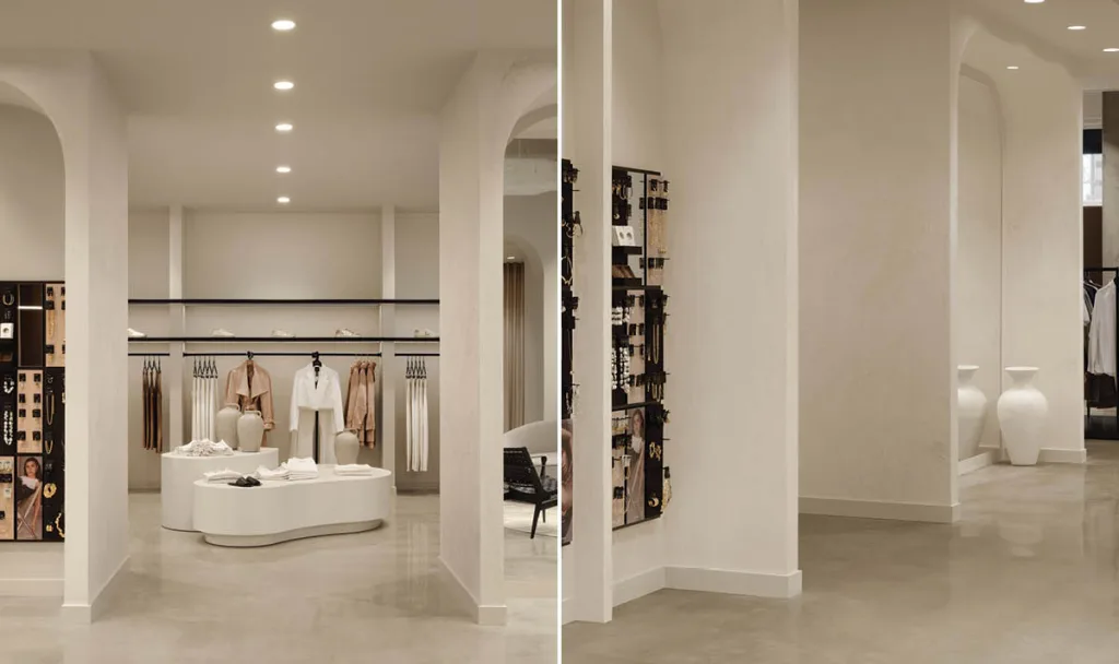 Area espositiva della Boutique Klozet a Moncton con pedane sinuose, abiti neutri e pareti in intonaco chiaro