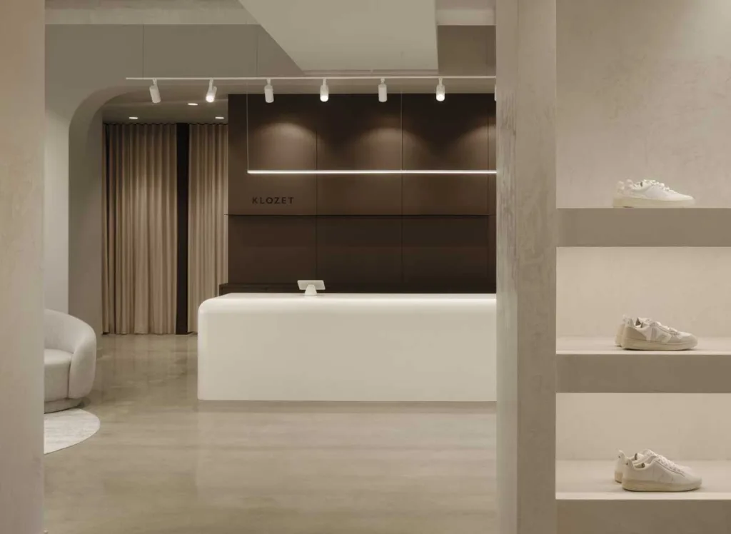 Vista del bancone cassa in Corian della Boutique Klozet a Moncton con pareti scure e scaffali espositivi per calzature