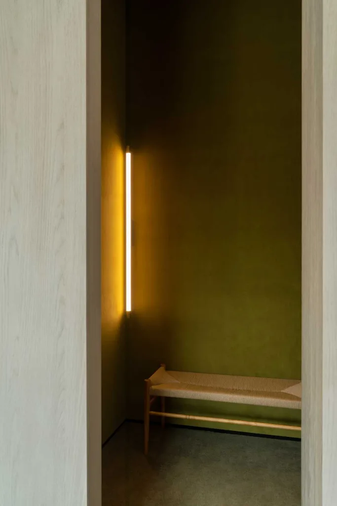 Dettaglio del camerino con pareti verde muschio e luce verticale del concept store 7+ Select Shop – Glimmering Bay a Zhengzhou progettato da say architects
