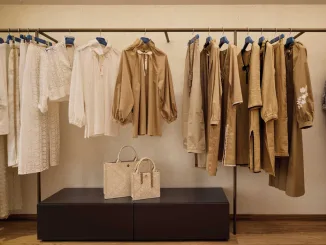 Abiti in tonalità neutre e borse esposte all’interno del flagship store Safira Milano progettato da Flaviano Capriotti Architetti