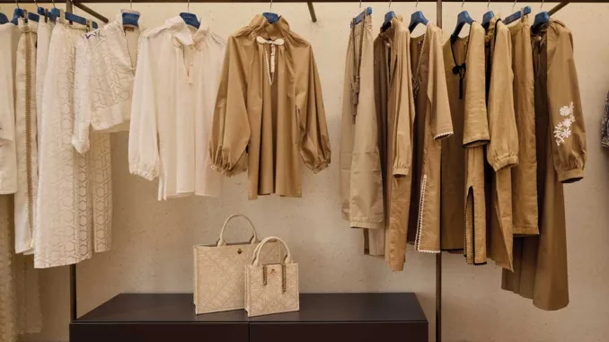 Abiti in tonalità neutre e borse esposte all’interno del flagship store Safira Milano progettato da Flaviano Capriotti Architetti