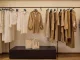 Abiti in tonalità neutre e borse esposte all’interno del flagship store Safira Milano progettato da Flaviano Capriotti Architetti