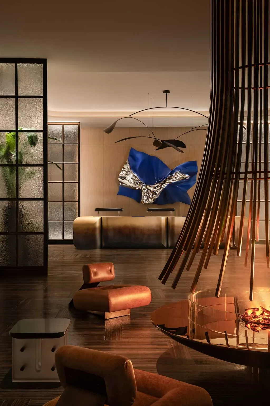 Lobby del Kimpton Aqeos Hainan con camino centrale, sculture e opere d’arte contemporanea.