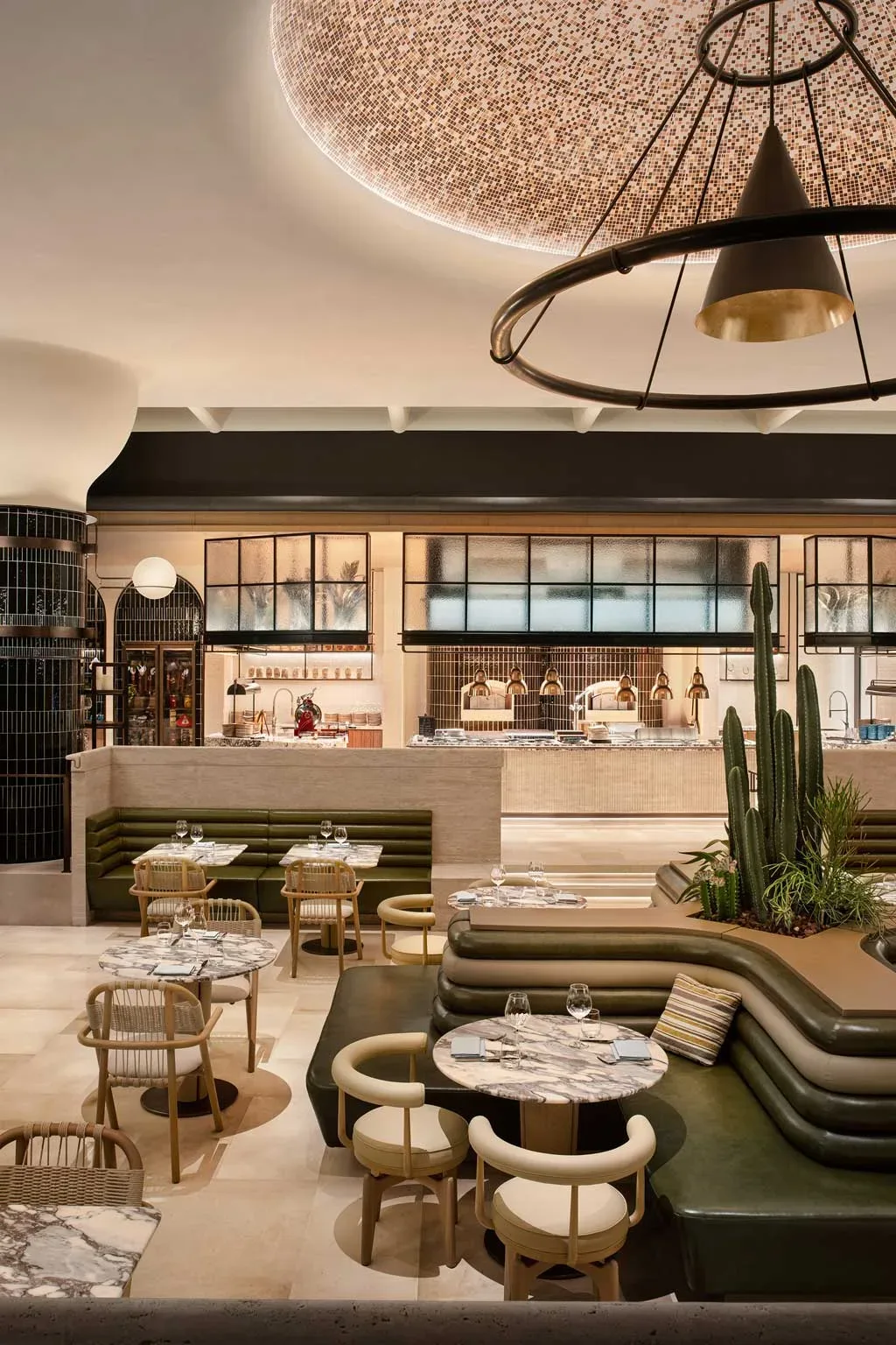 Ristorante all day dining del Kimpton Aqeos Hainan con tavoli in marmo e illuminazione scenografica.