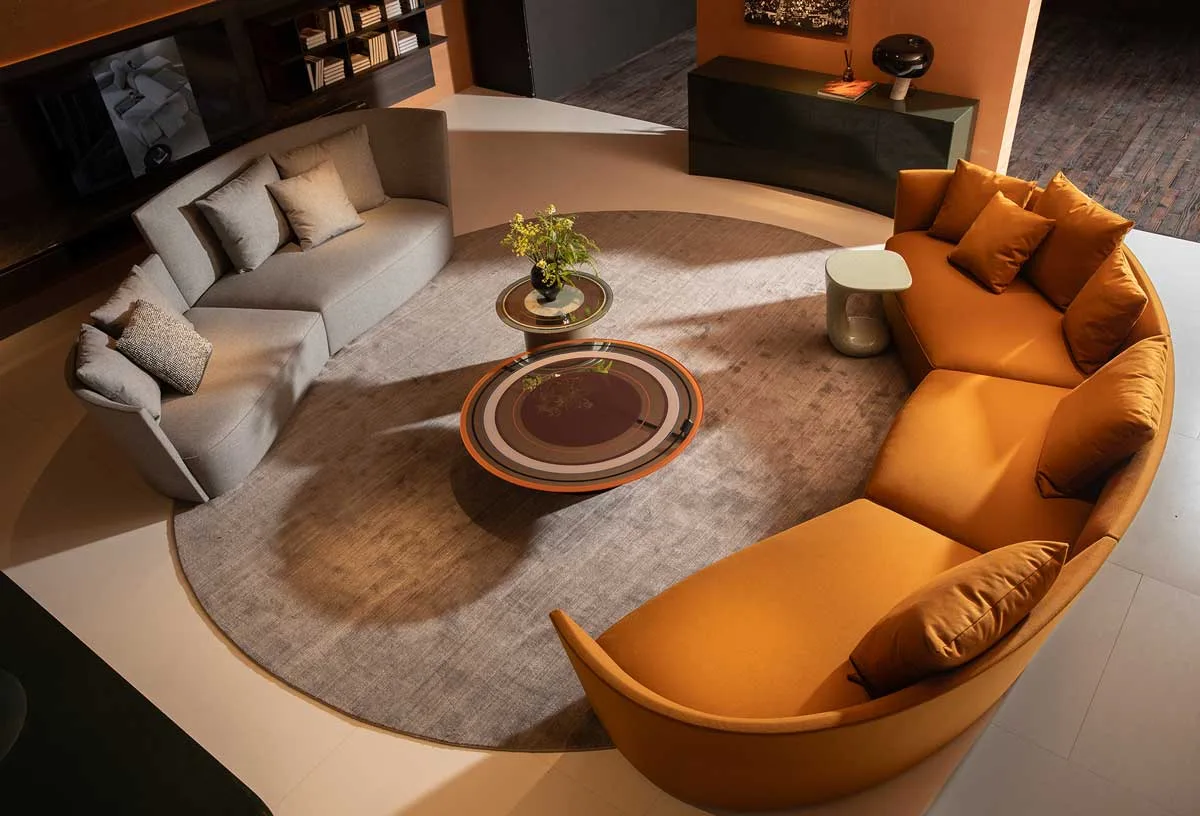 Pearson Lloyd curved living room for HC28 maison with semicircular sofas, central coffee tables, and round rug