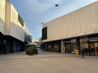 Vista del San Marino Outlet Experience con facciate in pietra chiara, negozi come Pinko e spazi pedonali ampi.