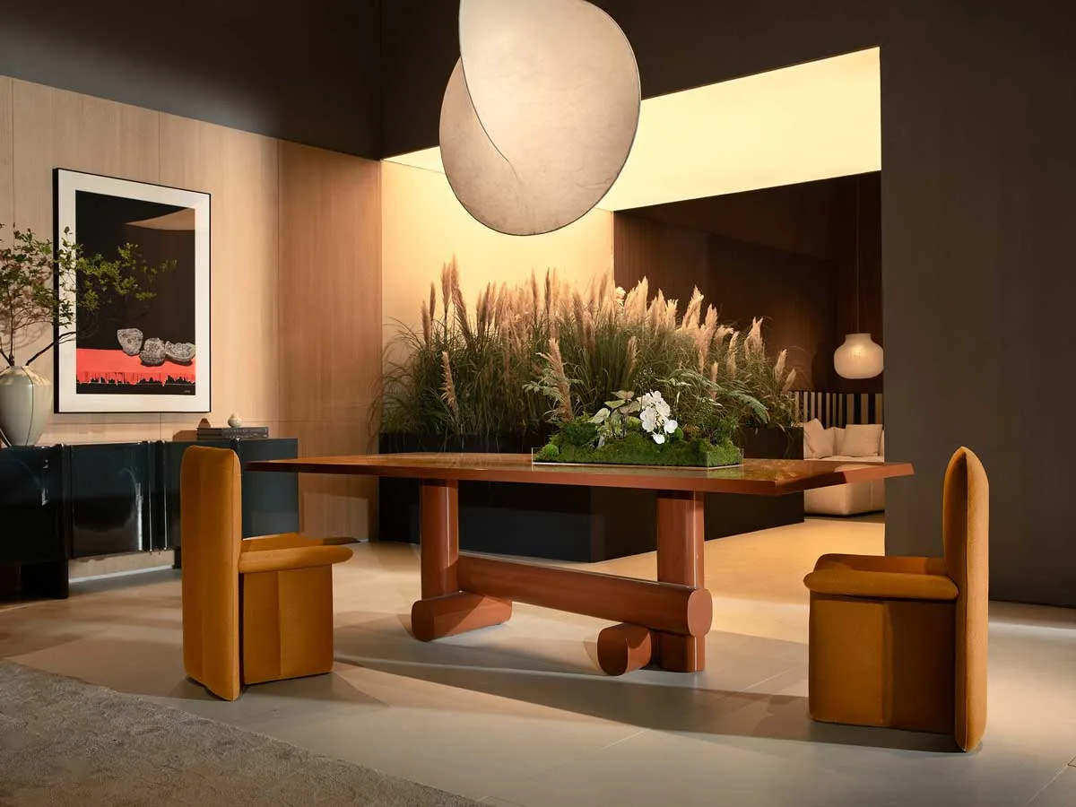 C28 maison dining area with sculptural table, upholstered seating, and decorative botanical installation