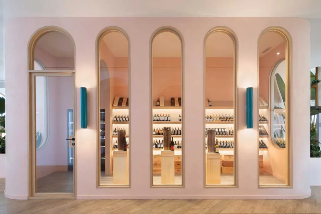 Area enoteca del ristorante La Terrassa del Mar al Le Méridien Ra Beach Hotel & Spa, con arredi su misura, nicchie ad arco e palette ispirata alle tonalità del tramonto mediterraneo
