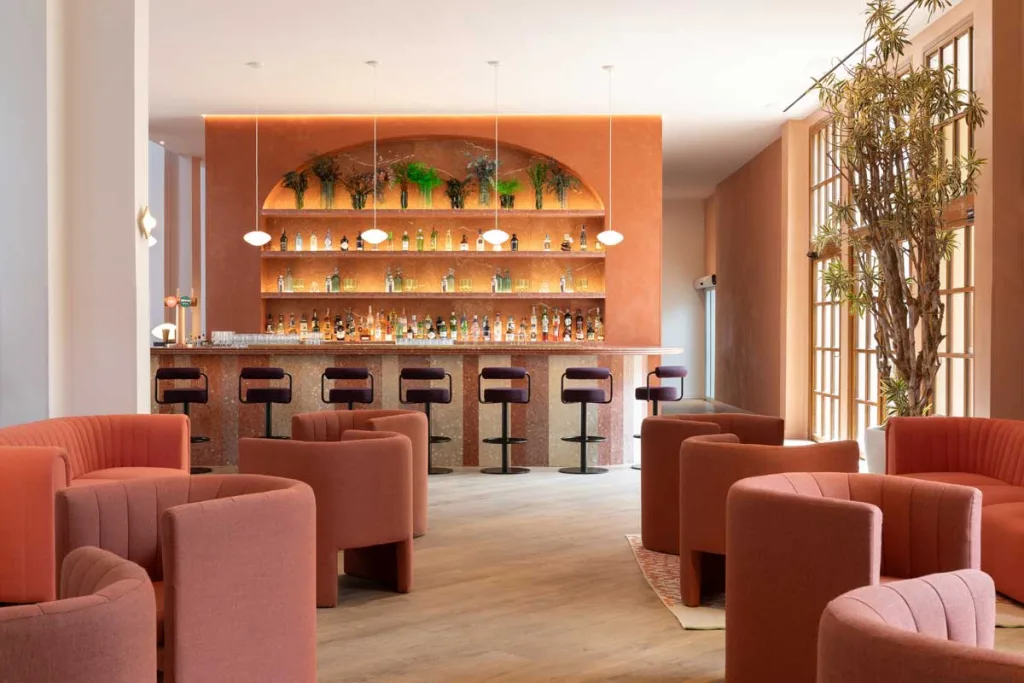 Bancone del Bar Tempus al Le Méridien Ra Beach Hotel & Spa caratterizzato da tonalità terracotta, sedute su misura e dettagli in terrazzo firmati Transit Studio