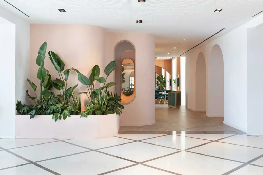 Ingresso del ristorante La Terrassa del Mar al Le Méridien Ra Beach Hotel & Spa, con pareti sinuose, piante tropicali e giochi di luce che introducono all’atmosfera mediterranea del progetto