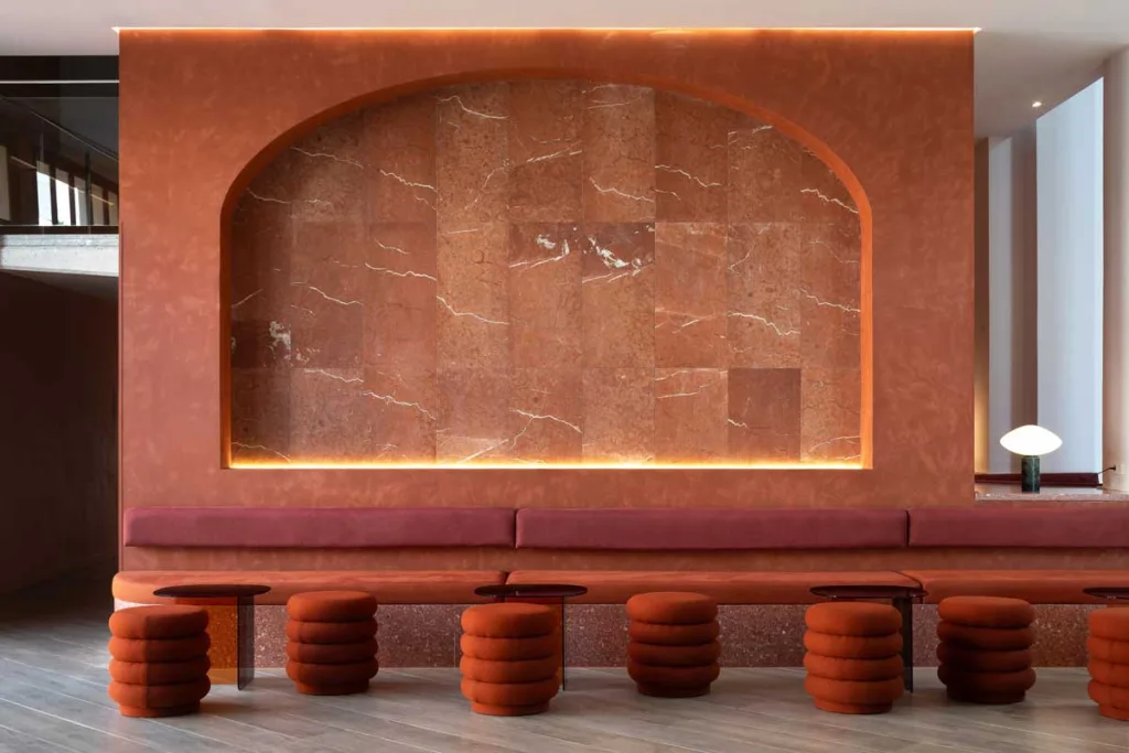 Area lounge del Bar Tempus al Le Méridien Ra Beach Hotel & Spa, caratterizzati da tonalità terracotta, sedute su misura e dettagli in terrazzo firmati Transit Studio