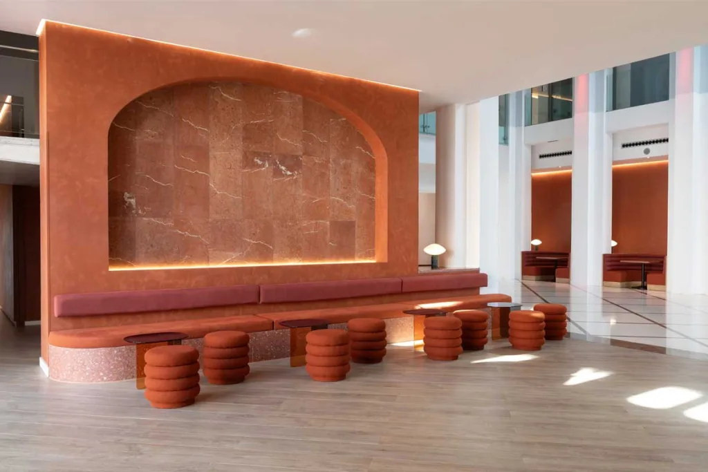 Area lounge del Bar Tempus al Le Méridien Ra Beach Hotel & Spa, caratterizzato da tonalità terracotta e dettagli in terrazzo firmati Transit Studio