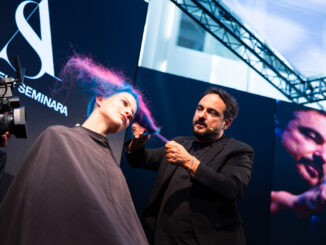 Performance live a On Hair Show: hairstylist lavora su capelli colorati blu e fucsia durante lo show a Cosmoprof Bologna