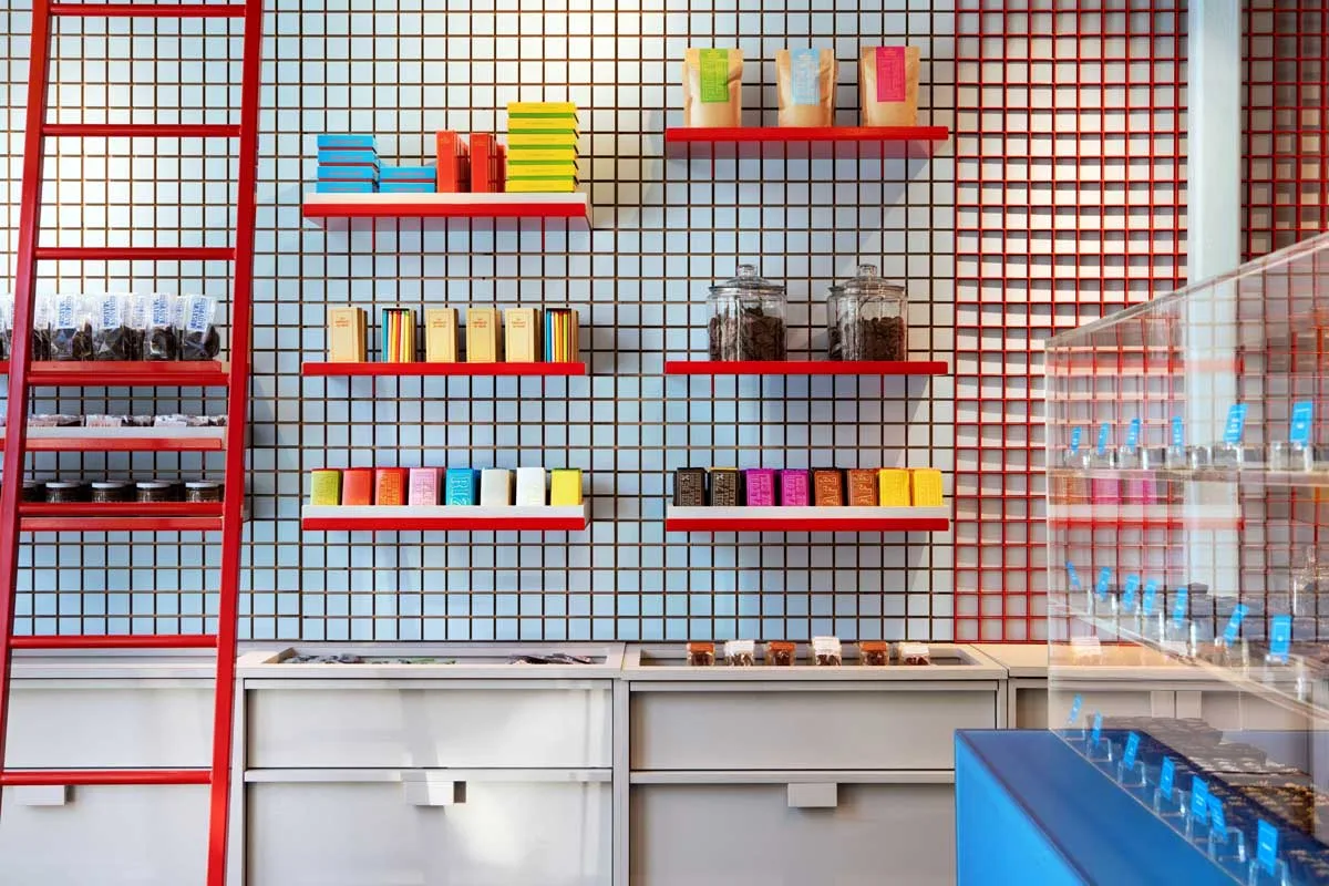 Interior della Les Chocolats de Chloé boutique con griglia modulare rossa e scala mobile
