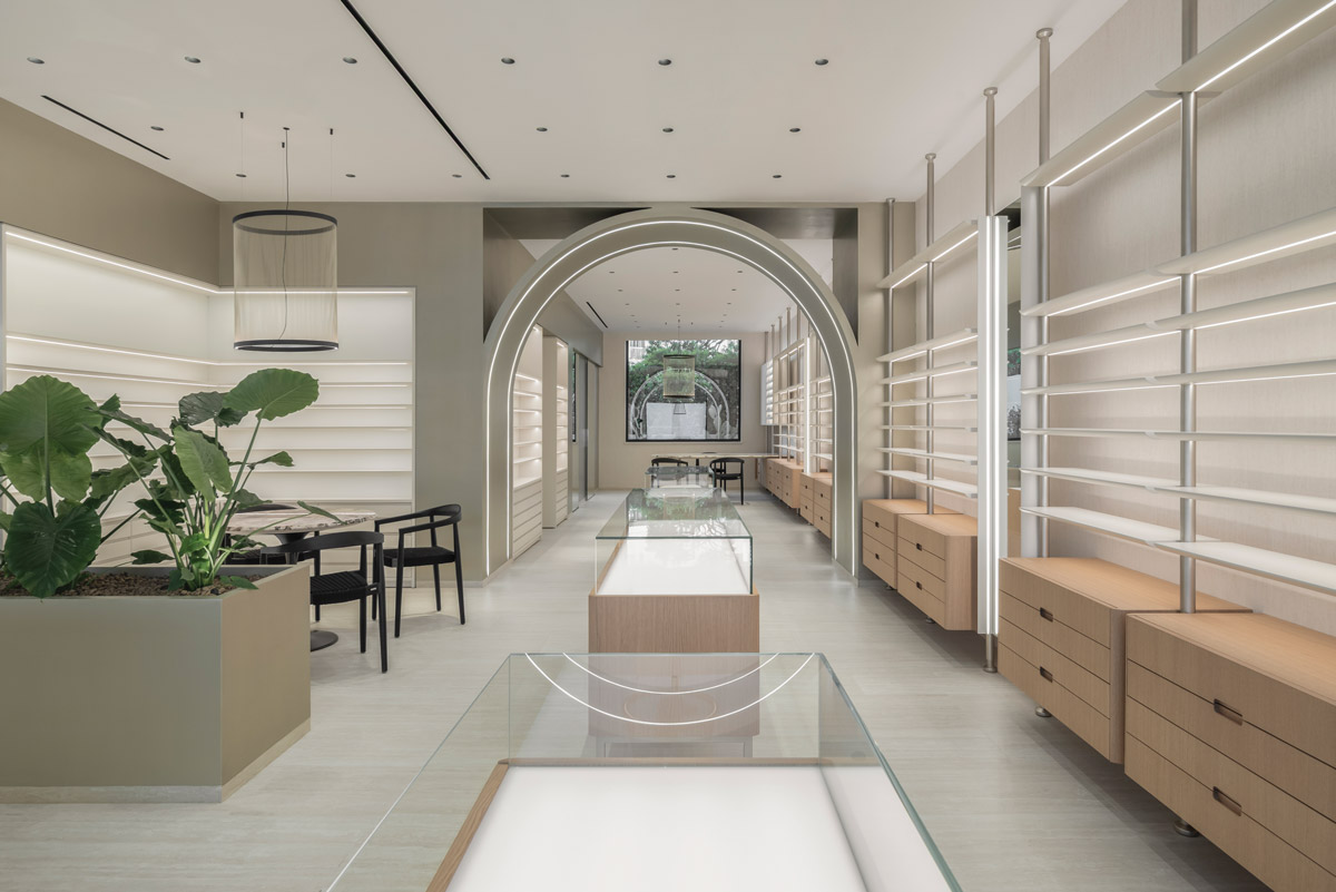 Central gallery space with illuminated arches and custom display furniture inside Optica Alessandro, Ragusa