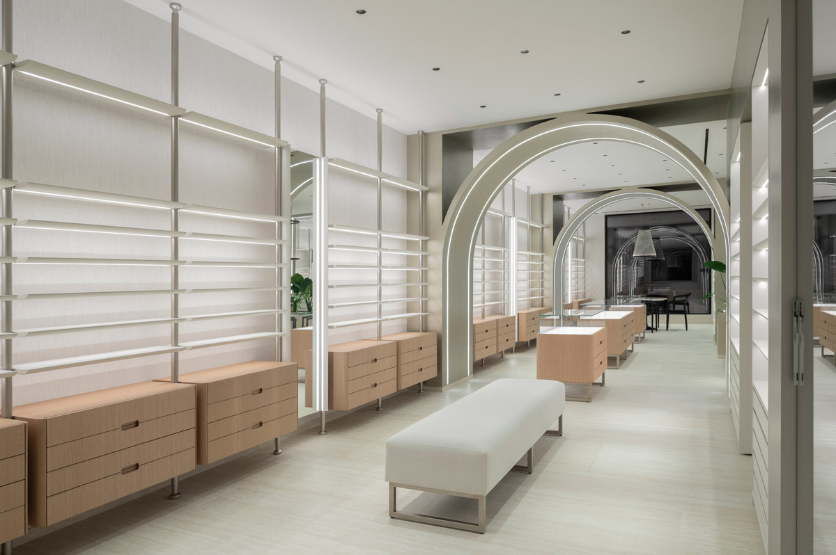 Custom wall-mounted display systems with integrated LED lighting in Optica Alessandro optical store
