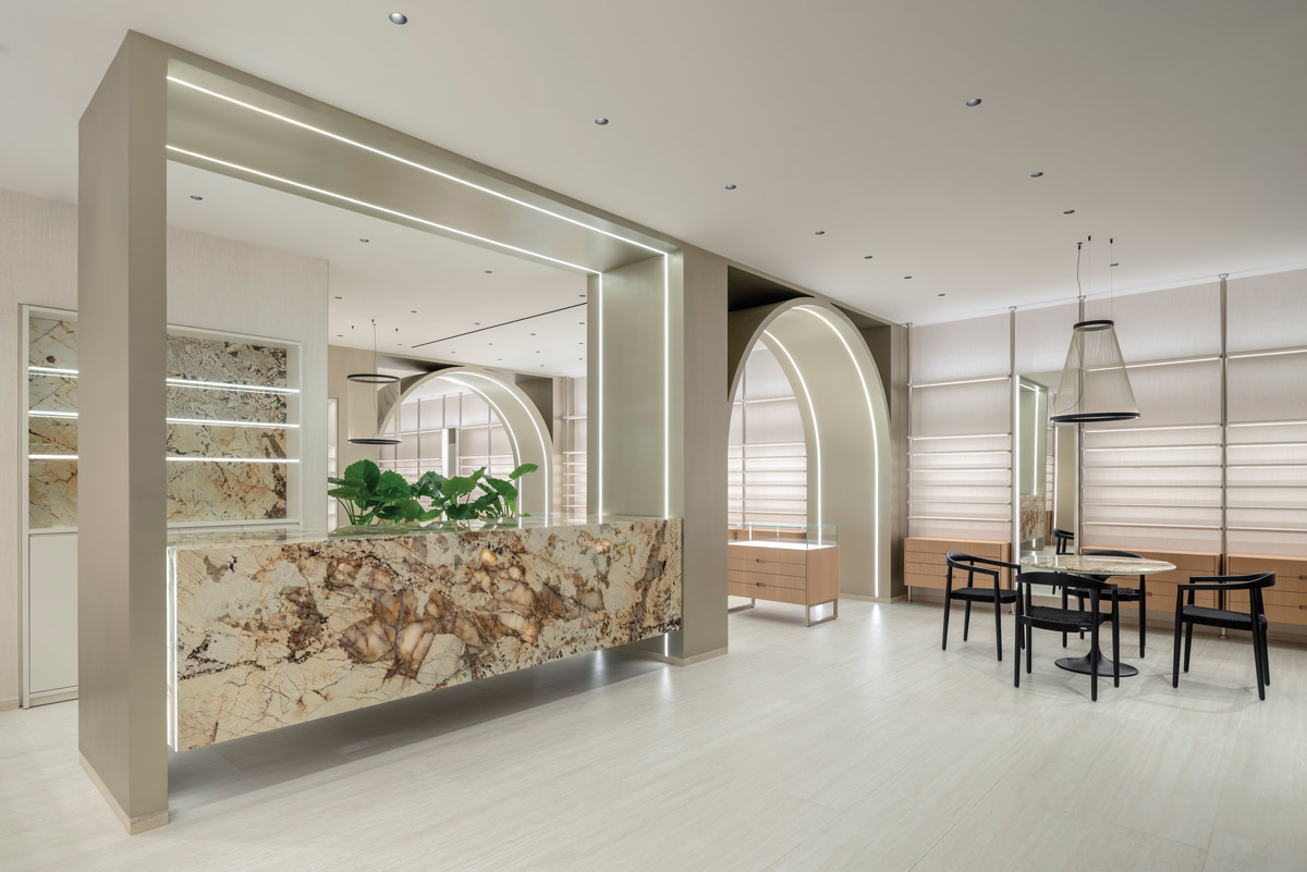 Interior view of Optica Alessandro in Ragusa with illuminated marble Patagonia counter and minimalist exhibition layout