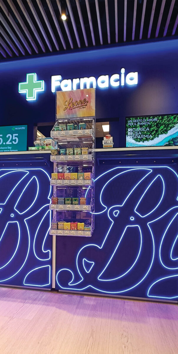 Pharmacy counter with illuminated graphics and Boots signage, interior design project in Milan