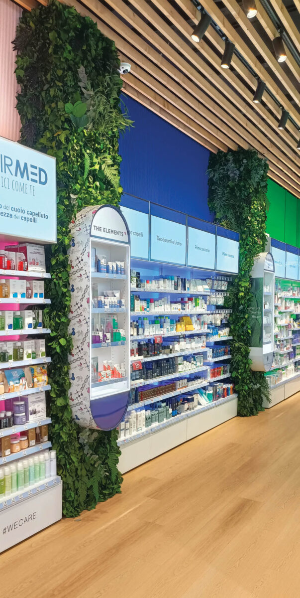 Pharmacy shelving with health and beauty products and integrated green columns in the layout